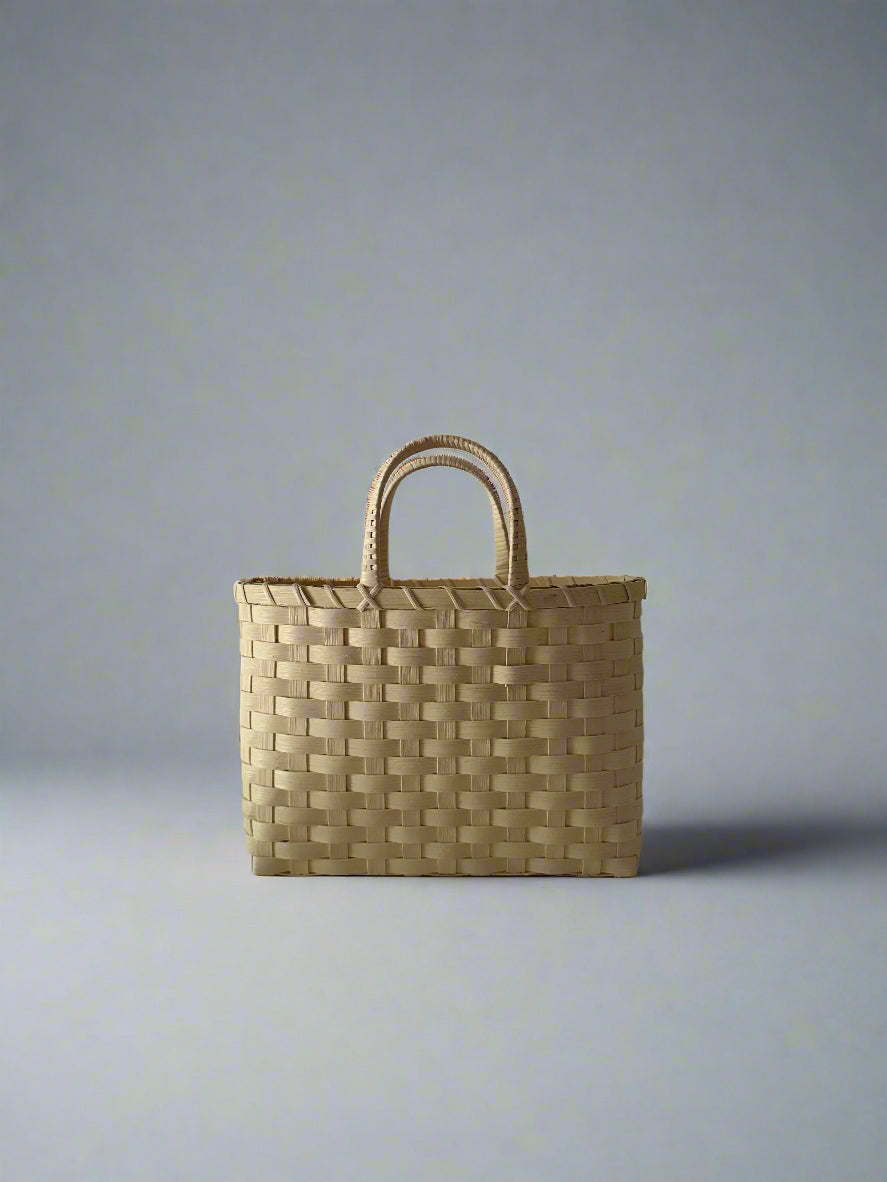 Woven basket with handles on a plain background