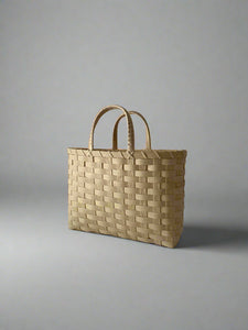 Woven beige tote bag on a plain background