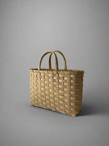 Woven basket with handles on a plain background