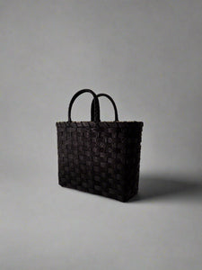 Black woven bag on a white background