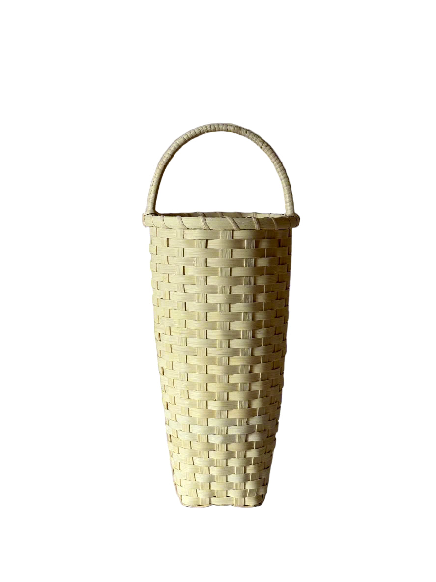 Woven basket with a handle on a gray background