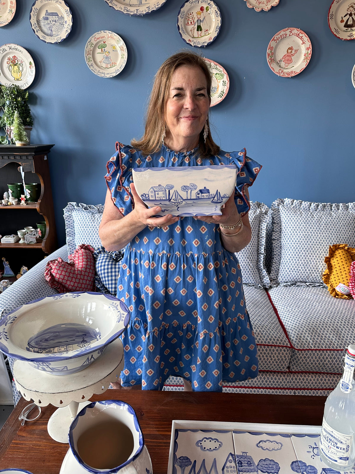 Front view of Nantucket Planter held by a woman showcasing hand-painted blue-and-white cottages and sailboats for scale