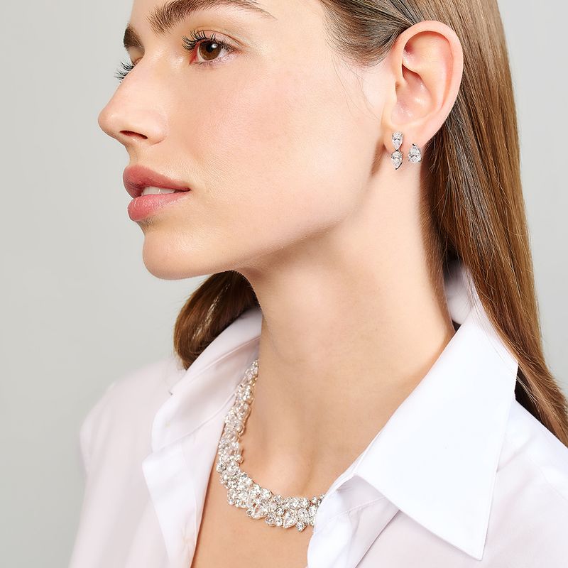 Left profile of model wearing Floating Diamonds Nova ear huggies with three floating diamonds on light gray background