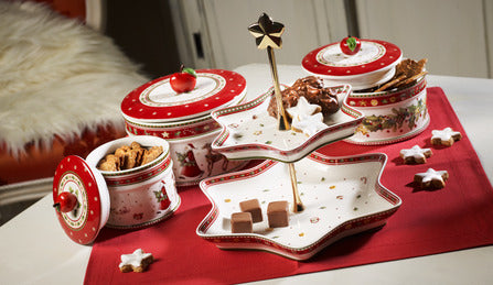 Angled view of Winter Bakery Delight large pastry box with festive illustrations and fitted lid with red berry knob on red table