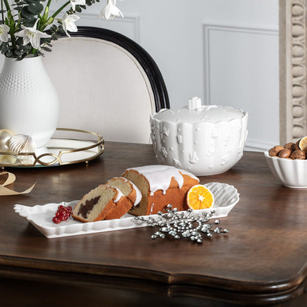 Angled view of Toys Delight Royal Classic sandwich plate in white porcelain showcasing embossed holiday detailing on wooden table
