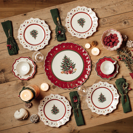 Overhead view of Toys Delight Cake Plate showcasing scalloped red border and central Christmas tree motif on a holiday table