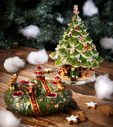 Three-quarter view of Christmas Toys Memory porcelain Christmas tree with children and matching candle wreath on wooden table