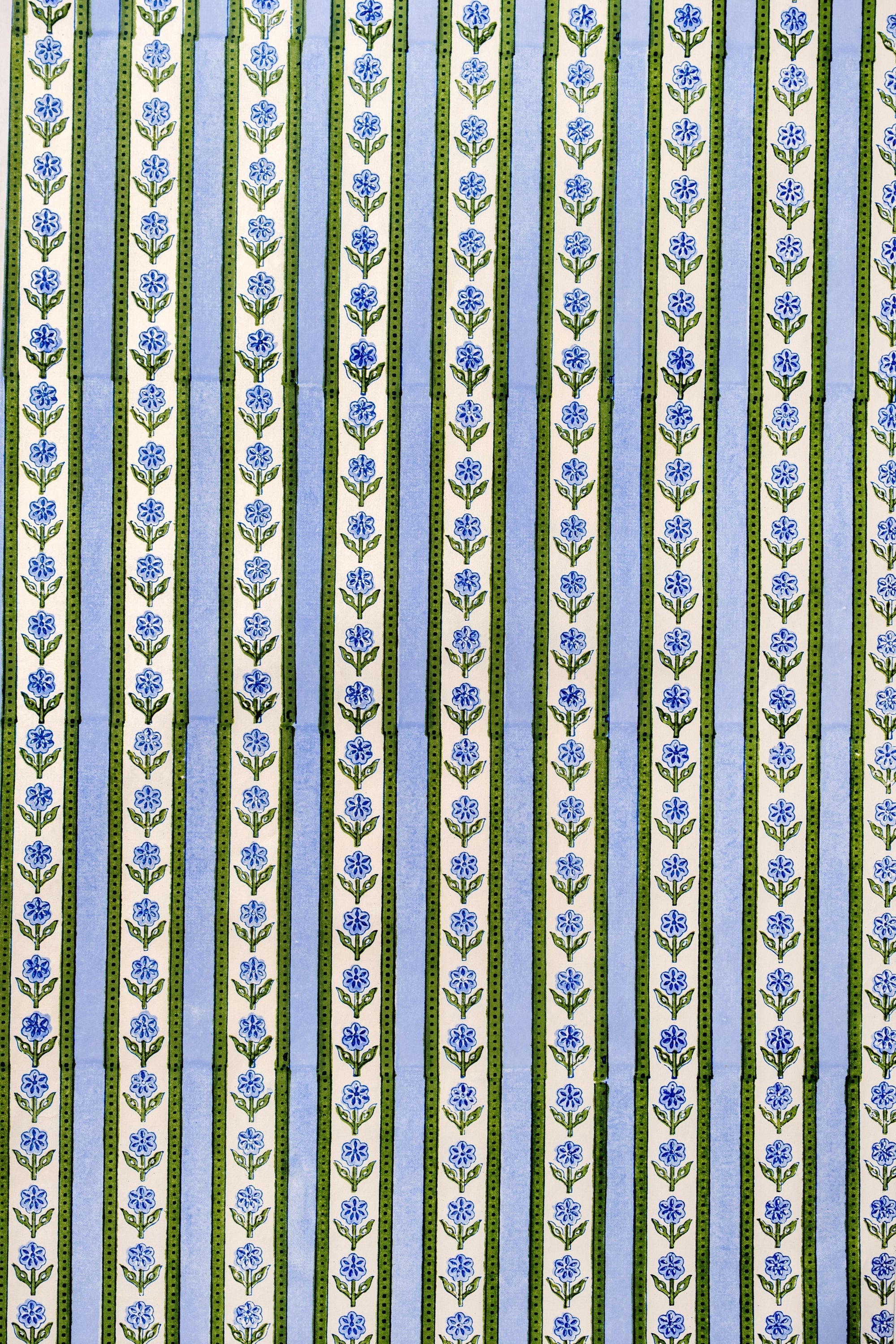 Close-up of Blockprint Cottage Garden gift wrapping paper sheets in blue showcasing vertical floral stripes