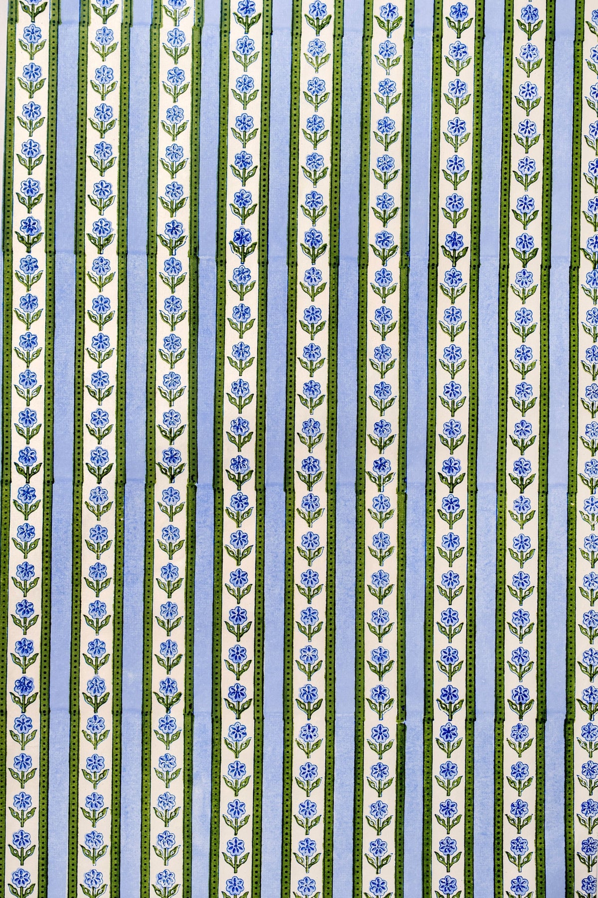 Close-up of Blockprint Cottage Garden gift wrapping paper sheets in blue showcasing vertical floral stripes