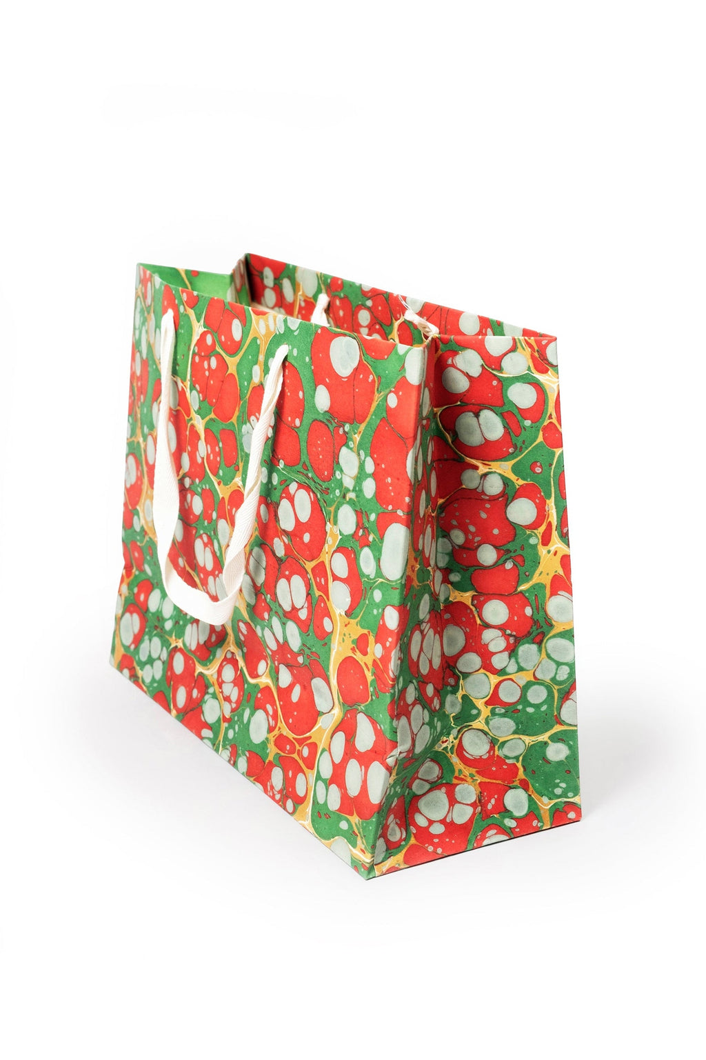 Christmas Gems hand-marbled gift bag in red, green, white, and gold with white handles, side view.