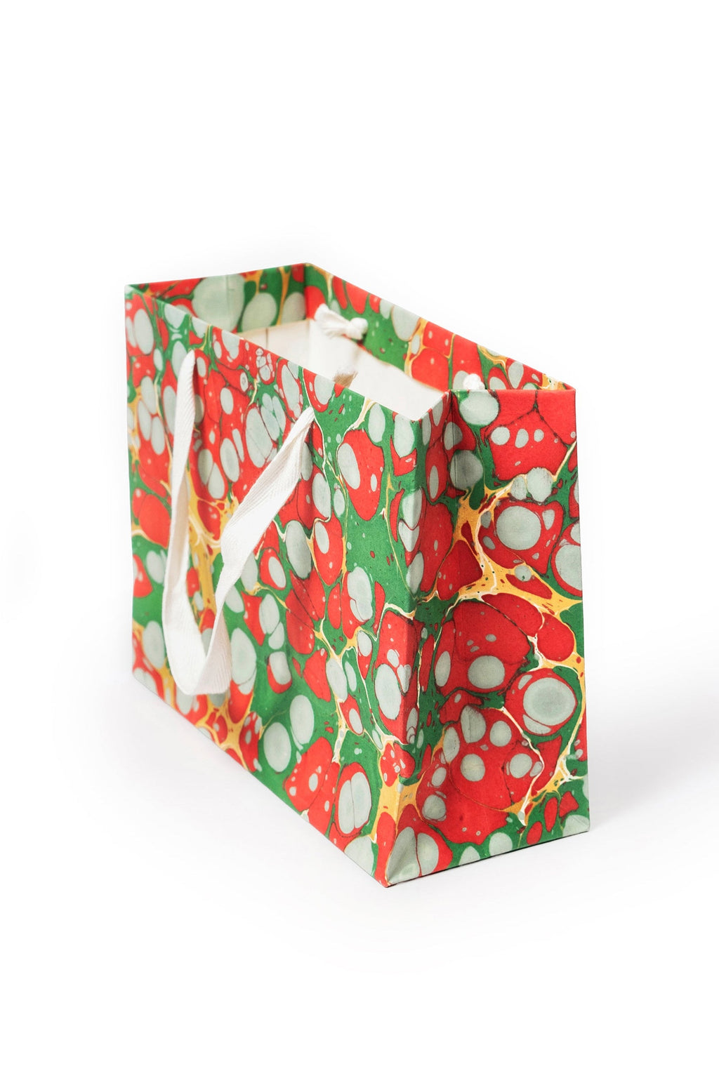 Christmas Gems hand-marbled gift bag in red, green, white, and gold with white handles, side view.