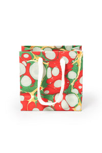 Small hand-marbled Christmas gift bag with red, green, white patterns and white handles
