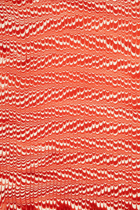 Red and white hand marbled candy cane swirl gift wrapping paper sheet close-up