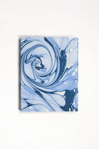 Close-up of hand-marbled ocean wave pattern on folding book frame