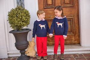 little english classic children's clothing boys navy sweater with cream lab motif, red piped peter pan shirt, and red banded corduroy pant. girls navy sweater with red bow on cream lab motif, smocked madeline blouse in red, and red leggings for fall 