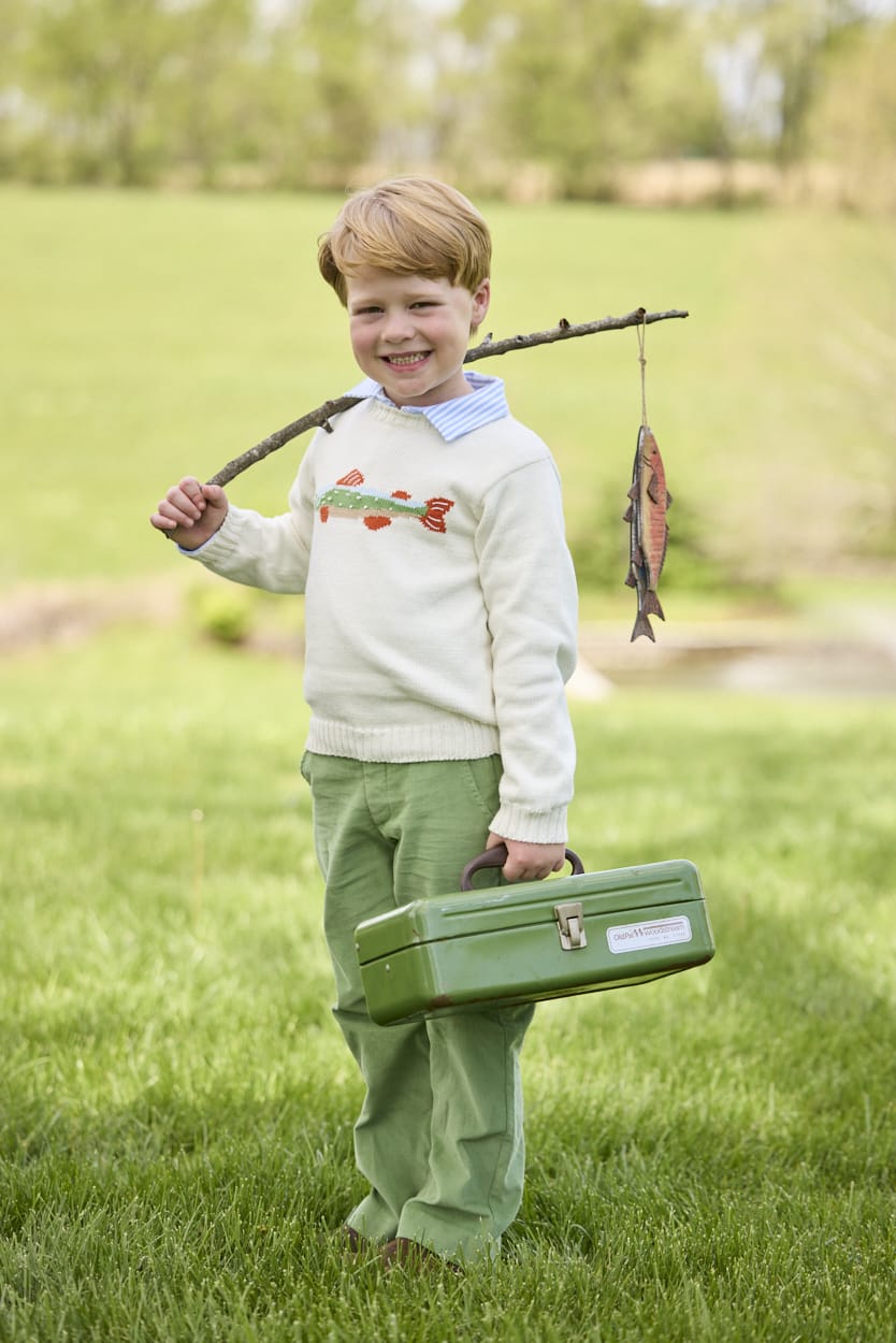 Little English traditional children's clothing.  Boys cream crew neck sweater with fish motif layered over light blue striped polo and paired with watercress green corduroy pants.