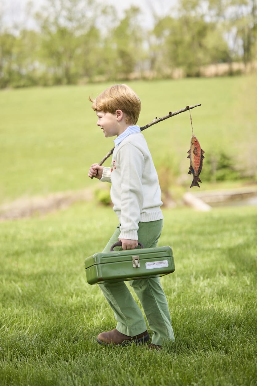 Little English traditional children's clothing.  Boys cream crew neck sweater with fish motif layered over light blue striped polo and paired with watercress green corduroy pants.