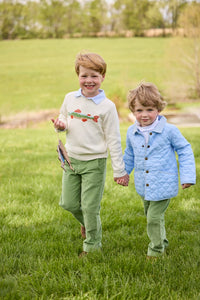 Little English traditional children's clothing.  Boys cream crew neck sweater with fish motif layered over light blue striped polo and paired with watercress green corduroy pants. Little boy wearing light blue quilted jacket with watercress green corduroy pull on pants