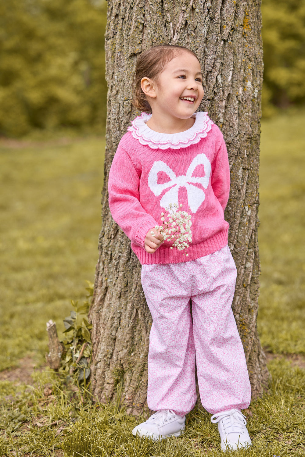 Full-length front view of Banded Bow Pant in Pink Vinings showing elastic waistband and pink floral print on child outdoors