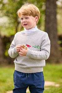Little English traditional children's clothing.  Grey intarsia sweater with 3 race cars layered over race car print turtleneck and paired with tapered navy sport pants for little boys.