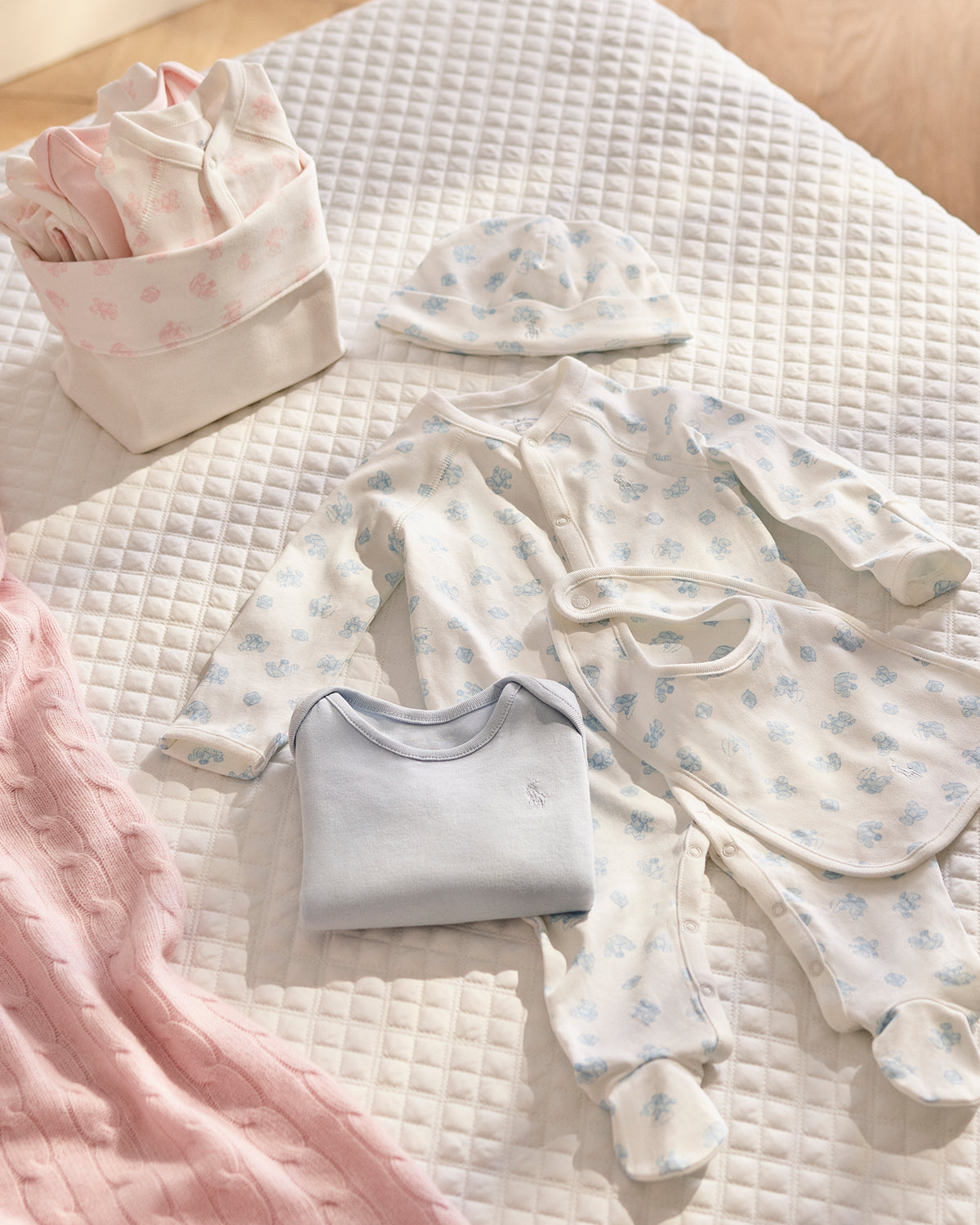 Top view of Organic Cotton 7-Piece Gift Set showcasing baby clothes and accessories on a white quilt