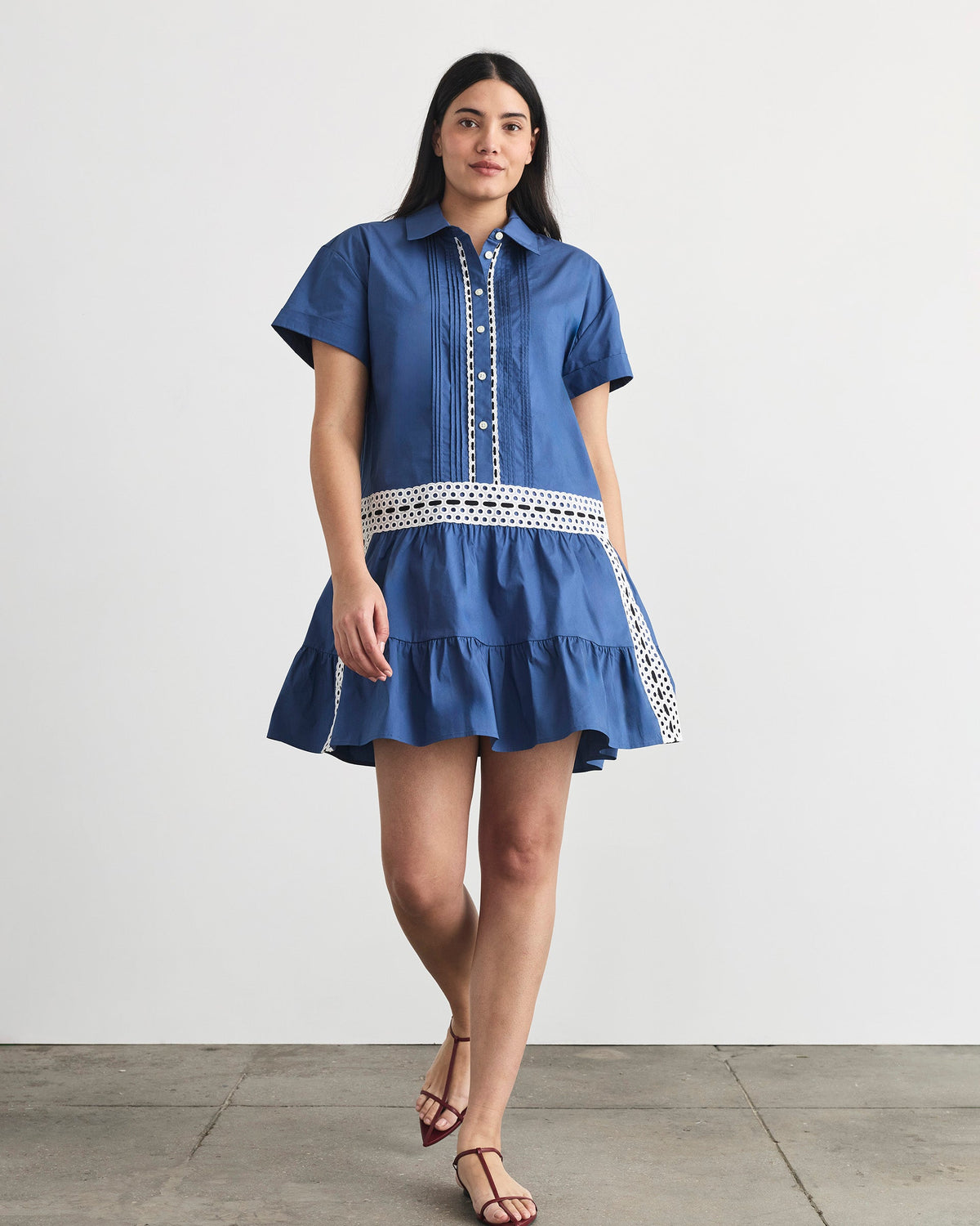 Front view of Jasmine Dress in French Blue with button-up V-neck, eyelet trim, and tiered flounce on white background