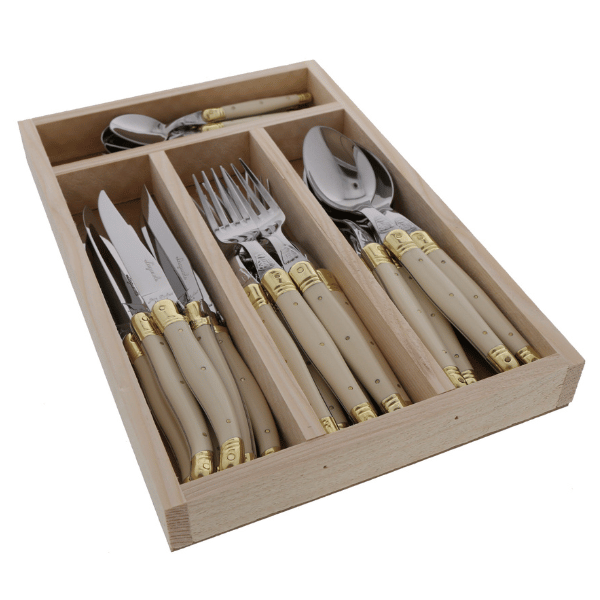 Angled view of Everyday Flatware Set showcasing ivory handles and brass detailing in a wooden tray