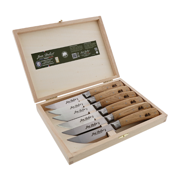 Angled view of Bistronomie steak knives showcasing six oak handles and Laguiole bee details in an open wooden box