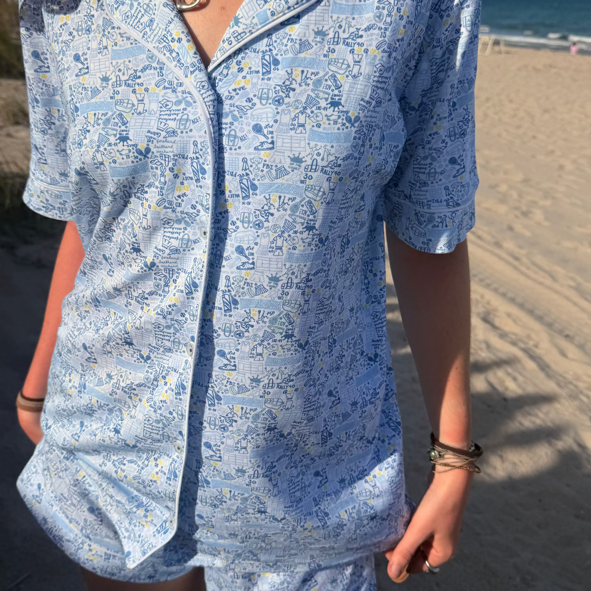 Front view of Tennis Women’s Button Front Short Pajama Set showcasing hand-drawn tennis print by the beach