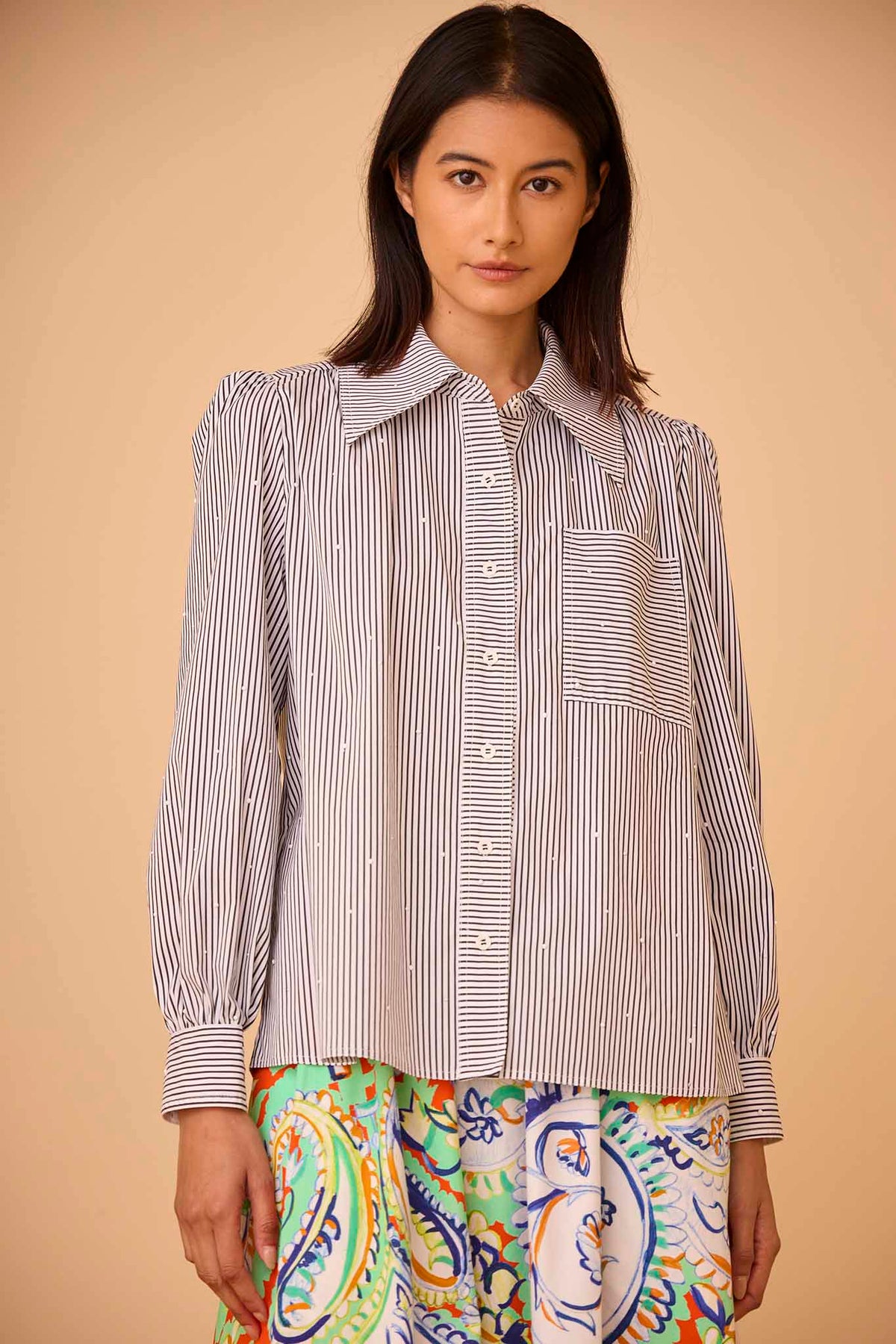 The Jade shirt is a long-sleeve collared shirt with roll-tab sleeves and white stone embellishments.