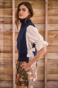 Navy wool blend turtleneck with an open side seam with embroidered eyelet ties.