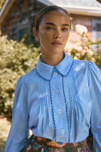 Blue and white gingham button down with a button front placket, shoulder puffing, and pintuck detail