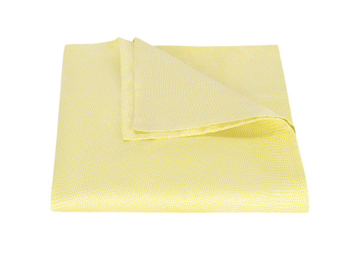 Folded Jasper duvet cover in lemon showing small dotted texture and folded corner revealing reverse on white background