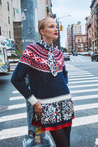 The Lila Dress is a mini with a tie neckline, long sleeves with button cuffs and a color block hem. 