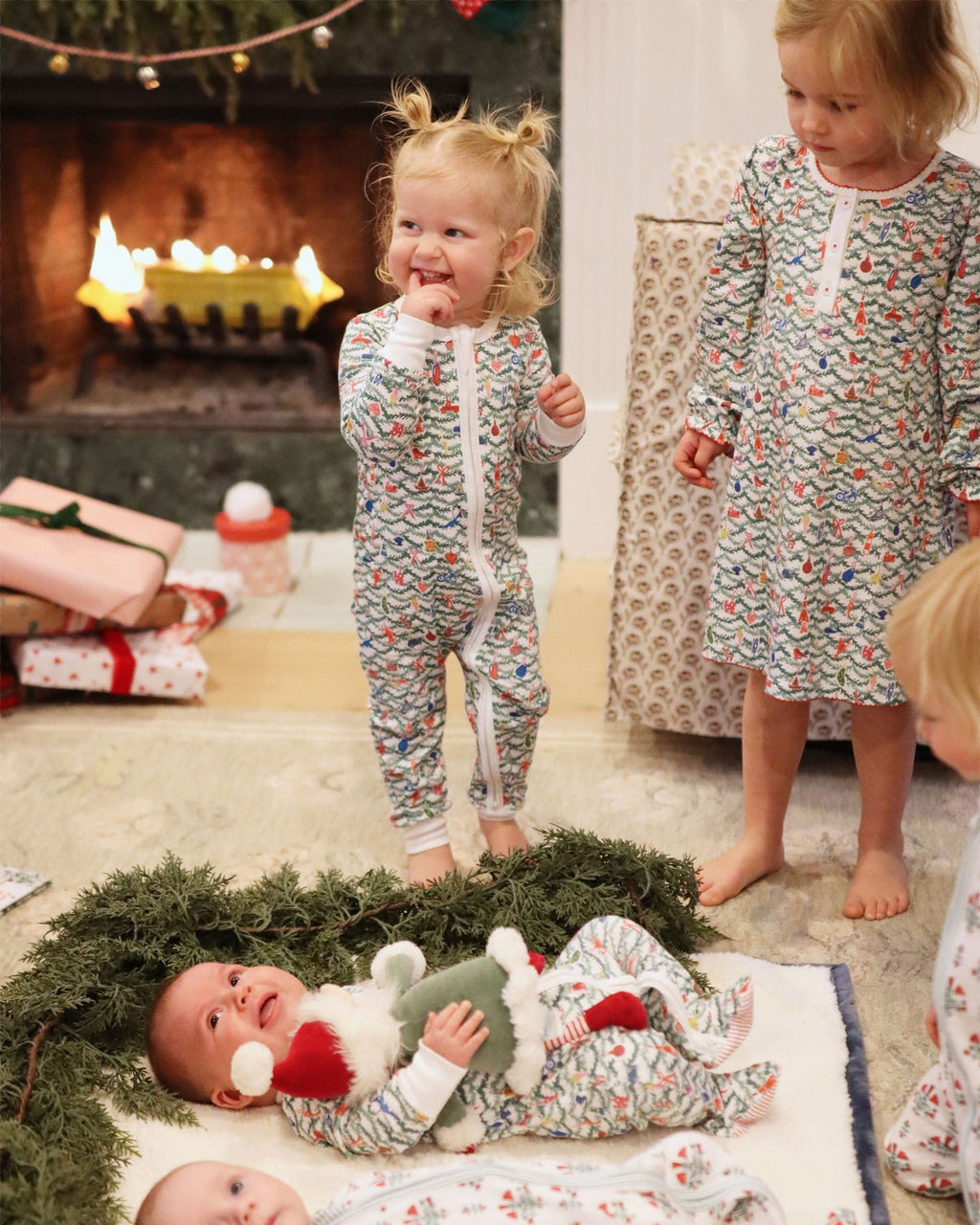 Full view of the Oh Christmas Tree Girls Tess Lounge Dress showcasing its hand-drawn evergreen and ornament print in a Christmas setting