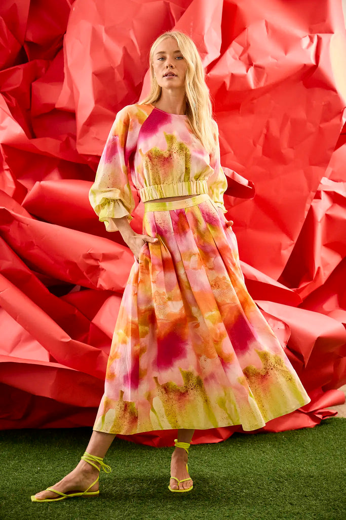A pleated full skirt in a colorful print with a matching long sleeve top