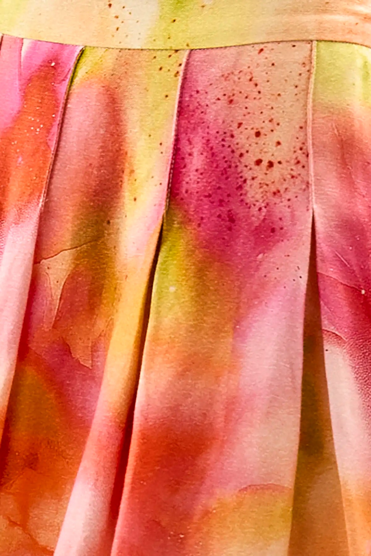 A pleated full skirt in a colorful print featuring pink, yellow, and orange