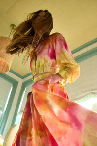 A pleated full skirt in a colorful print with a matching long sleeve top