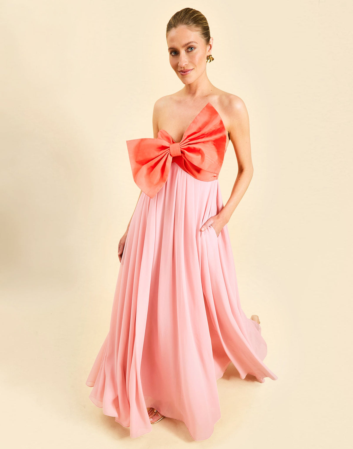 Kiss Me Knot Gown in Bloom Pink chiffon with oversized bow neckline, strapless silhouette, and flowing skirt.