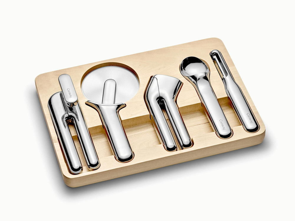 Angled view of kitchen gadget set with five polished stainless steel tools in birch wood organizer on white background