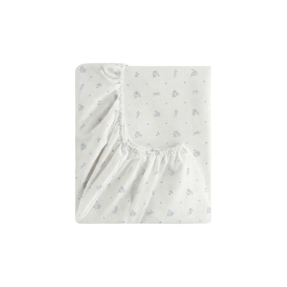 Fitted crib sheet with subtle pattern on a white background