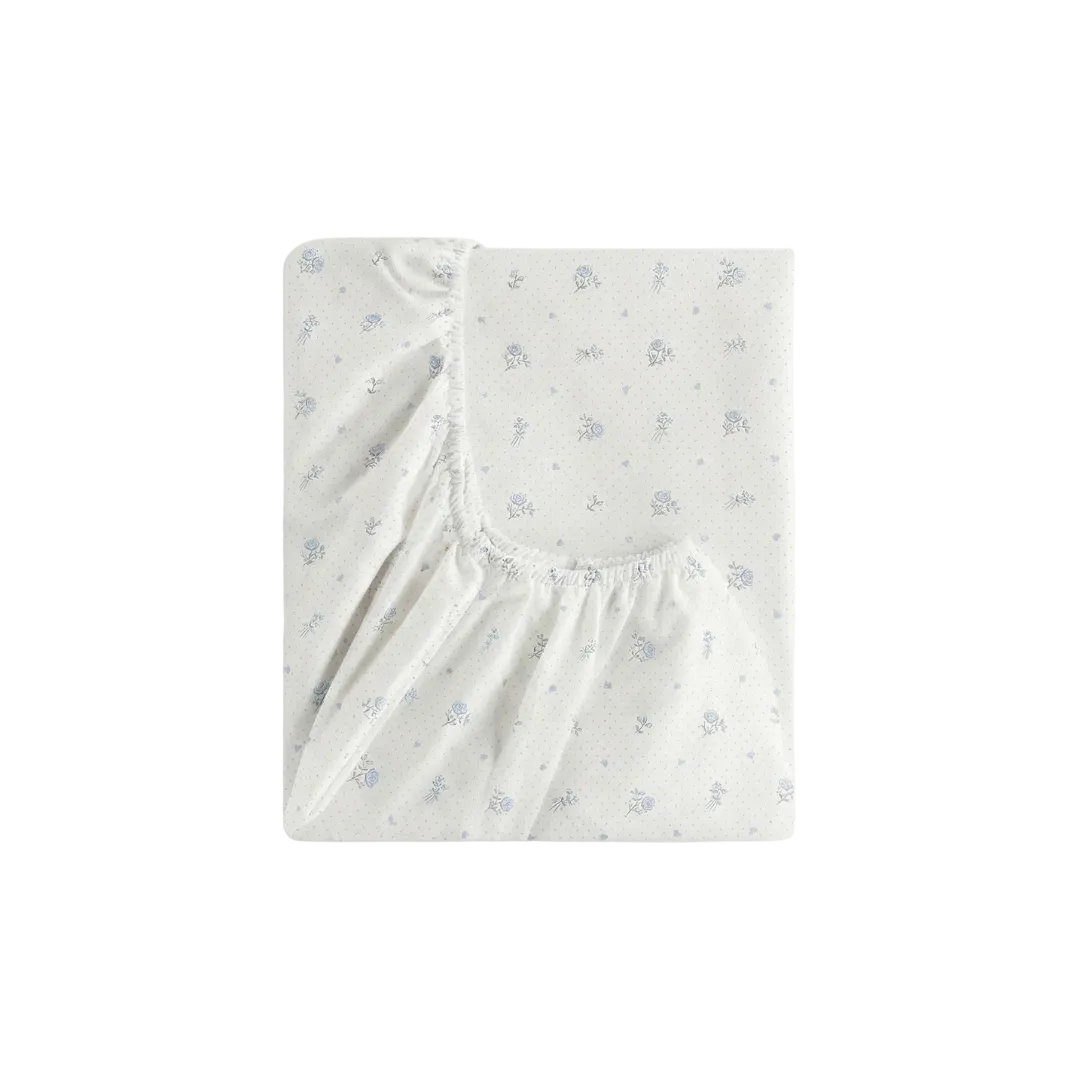 Fitted crib sheet with subtle pattern on a white background