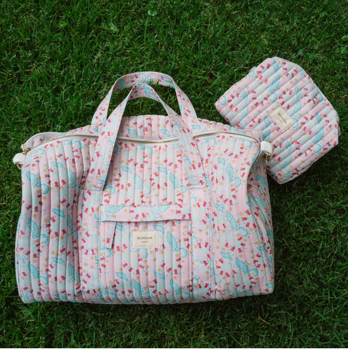Front view of Bluebells Quilted Cotton Weekender Bag showcasing quilted cotton and multiple zippered pockets on grass
