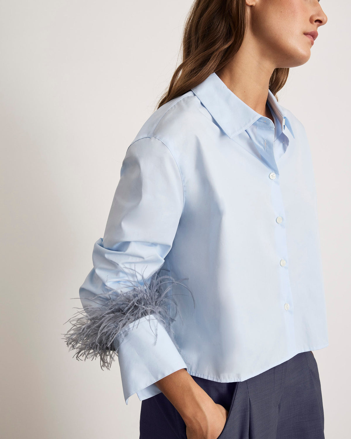 Close-up view of Largaux Feather Top in Oxford showcasing feather-trimmed cuff and button-front collar with neutral background