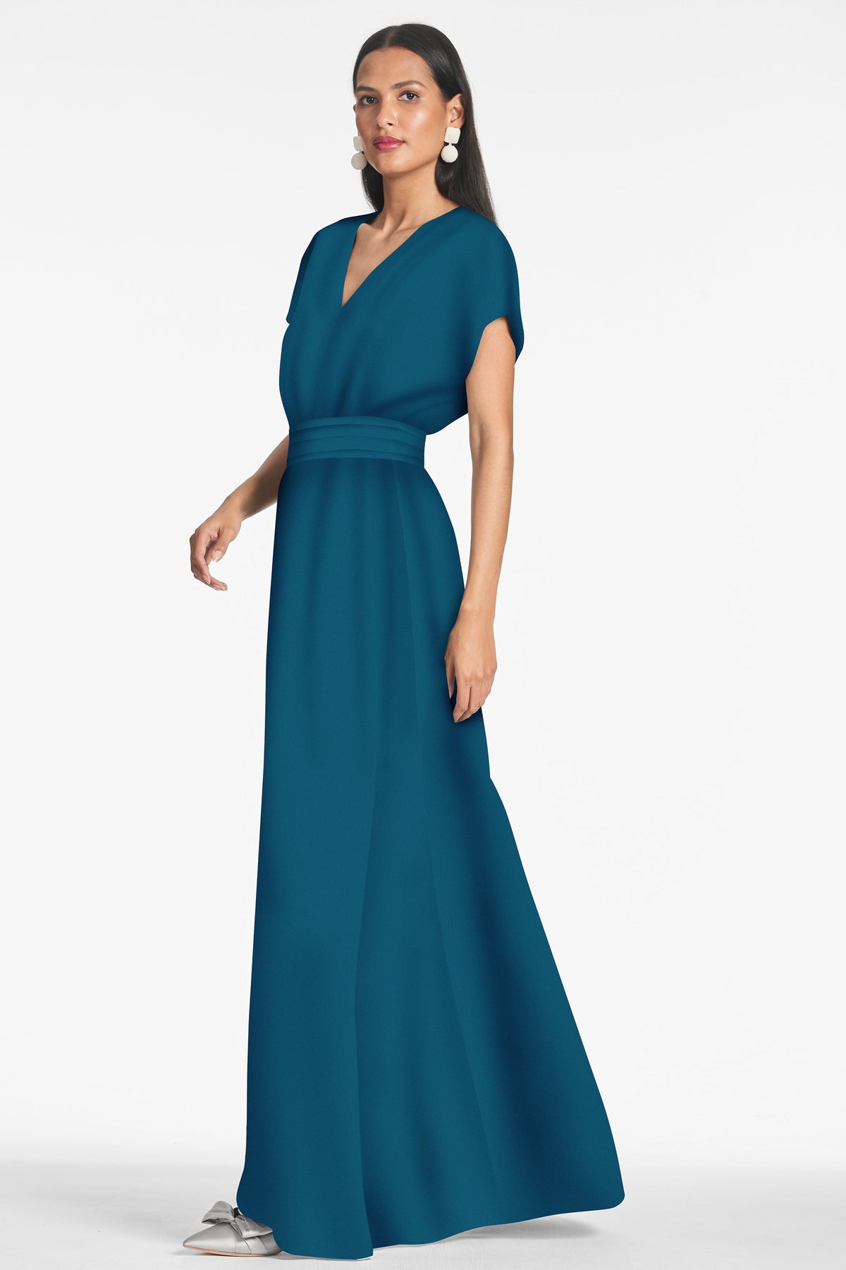Side view of Leah Gown in Bottle Green showcasing its V-neck and flutter sleeves with a white studio background