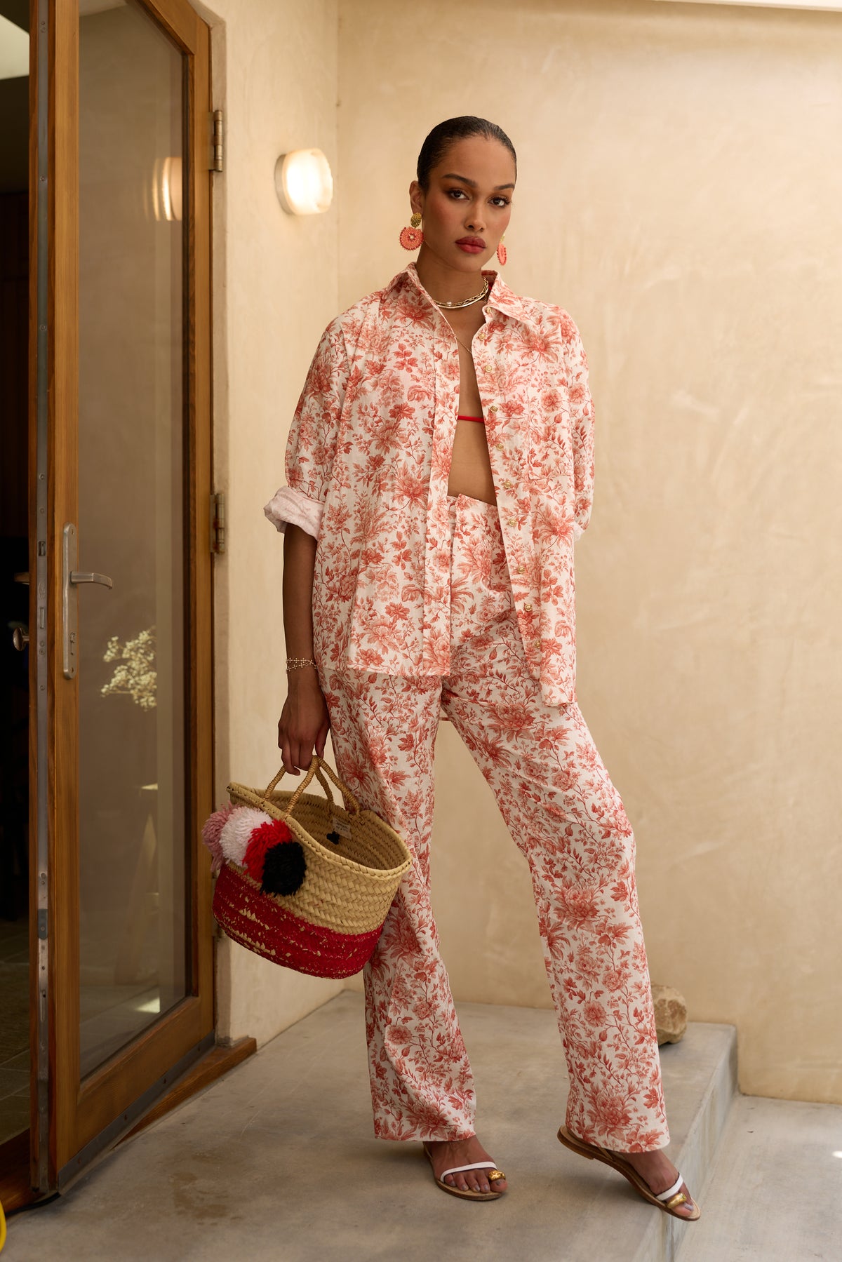 Front view of The Leo Pant in Red Toile showcasing its high-waisted pleated silhouette and floral pattern on a model
