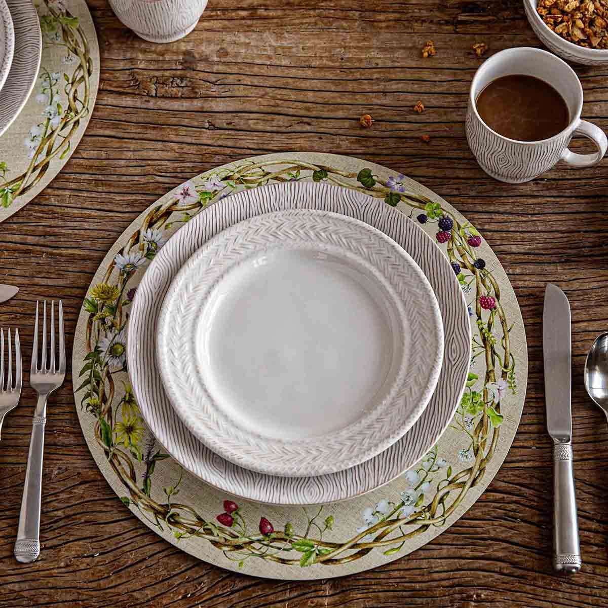 Top view of Meadow Walk Placemat in Multi, Set of 4 showcasing cream-colored cotton with wildflower, berry, and bramble border on a table