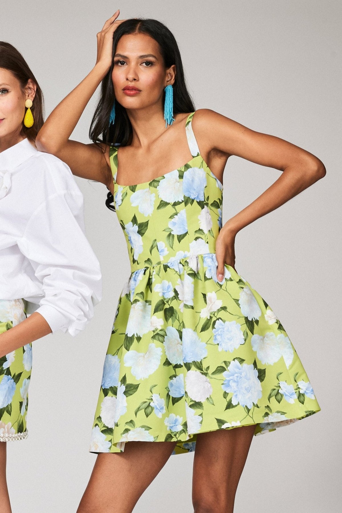 Front view of Samira dress in Citrine Peonies on model showcasing square neckline, thin straps, fitted bodice and A-line floral skirt on lime background