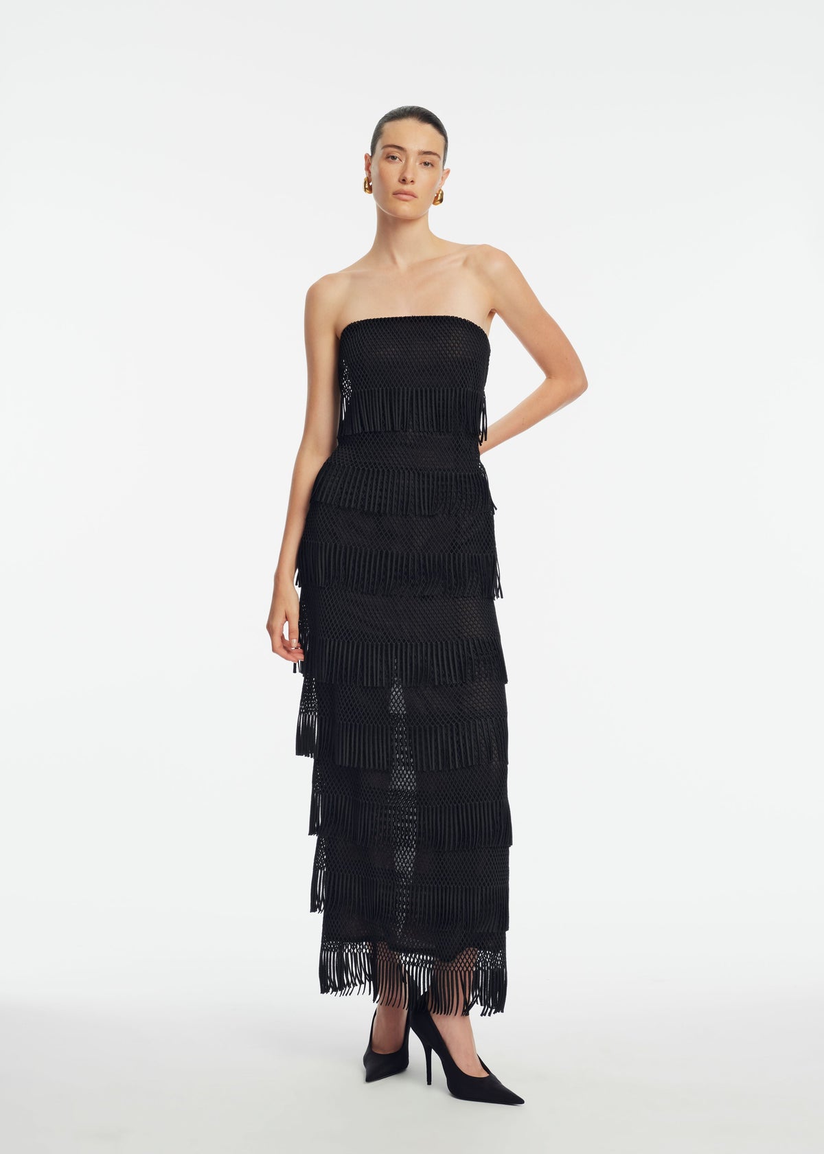 Front view of Macrame Lace Column Dress in Black showcasing strapless fitted bodice and fringe detailing on a white studio background