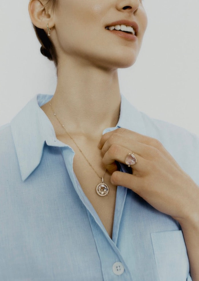 Close-up of Diamond Locket on Adjustable Rolo Gold Chain showcasing diamond border on a model in a light blue shirt
